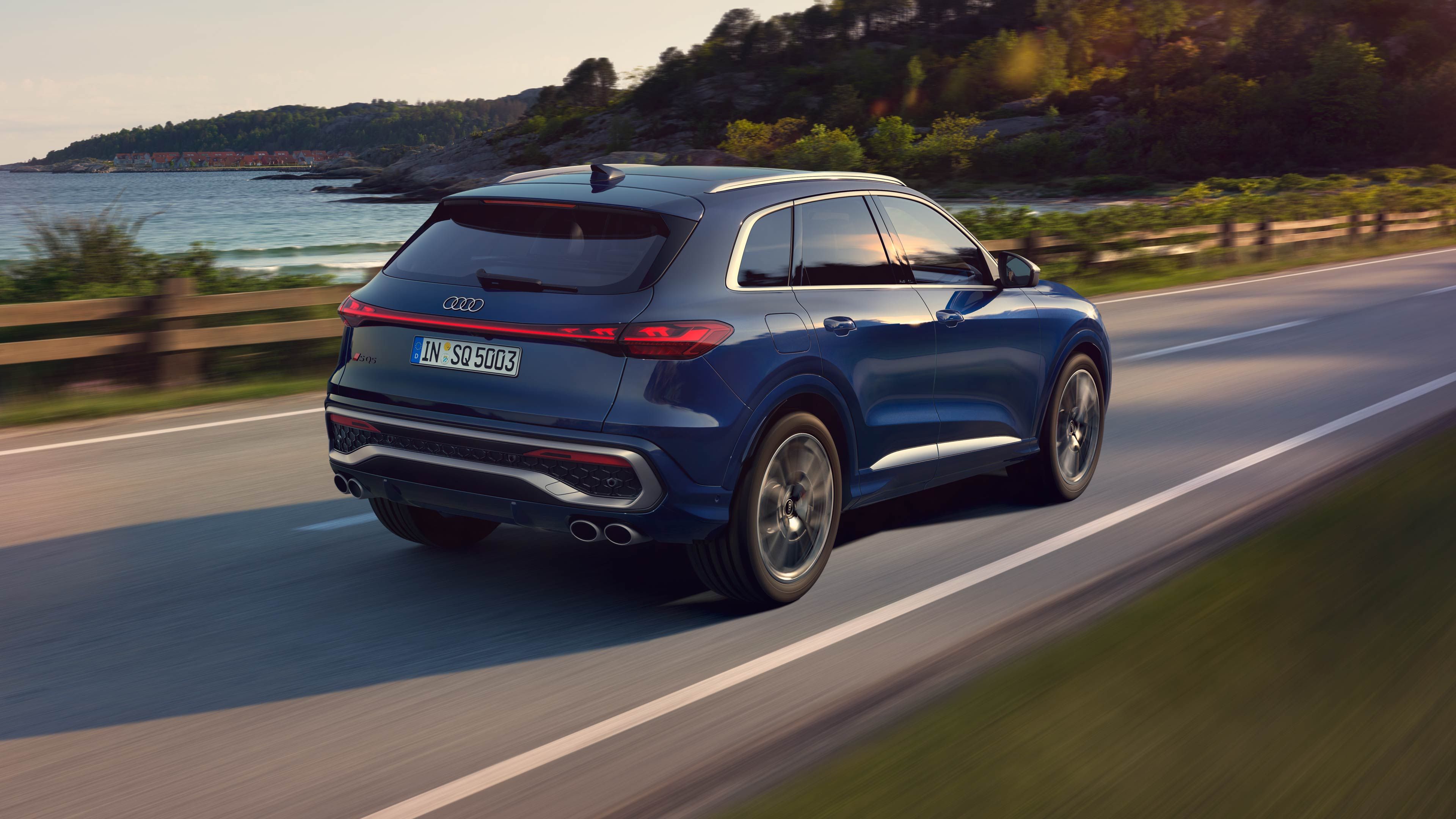 Seitliche Heckansicht eines fahrenden, blauen Audi SQ5 SUV