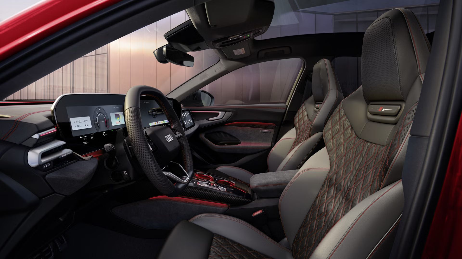 Blick durch die Fahrertür in das Cockpit der A5 Limousine. Die Bezüge im Interieur sind schwarz-jetgrau mit karmesinroten Kontrasten.
